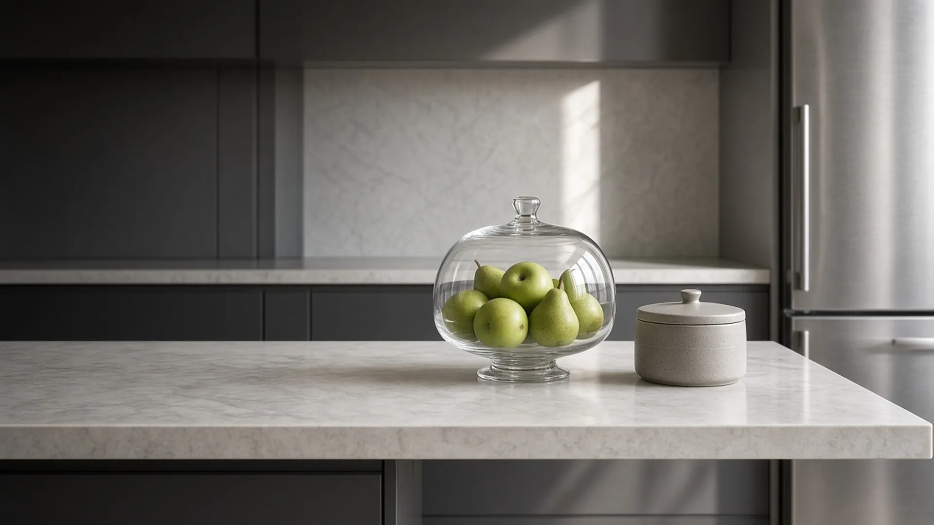 A covered fruit bowl and closed scrap caddy on a counter